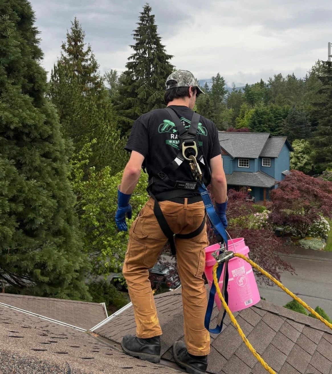 Rainlife Washing technician on roof applying soft wash treatment
