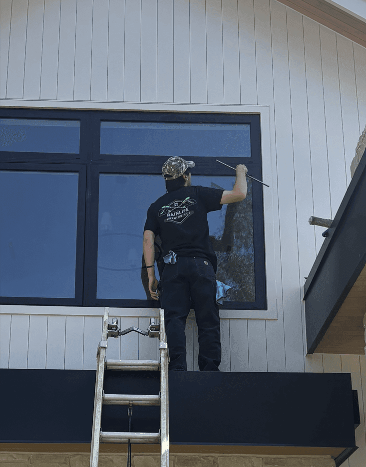 Rainlife Washing technician cleaning exterior windows streak-free
