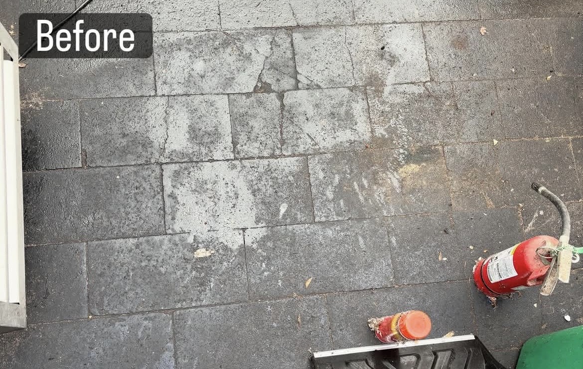 Paver surface before pressure washing — dark stained concrete pavers